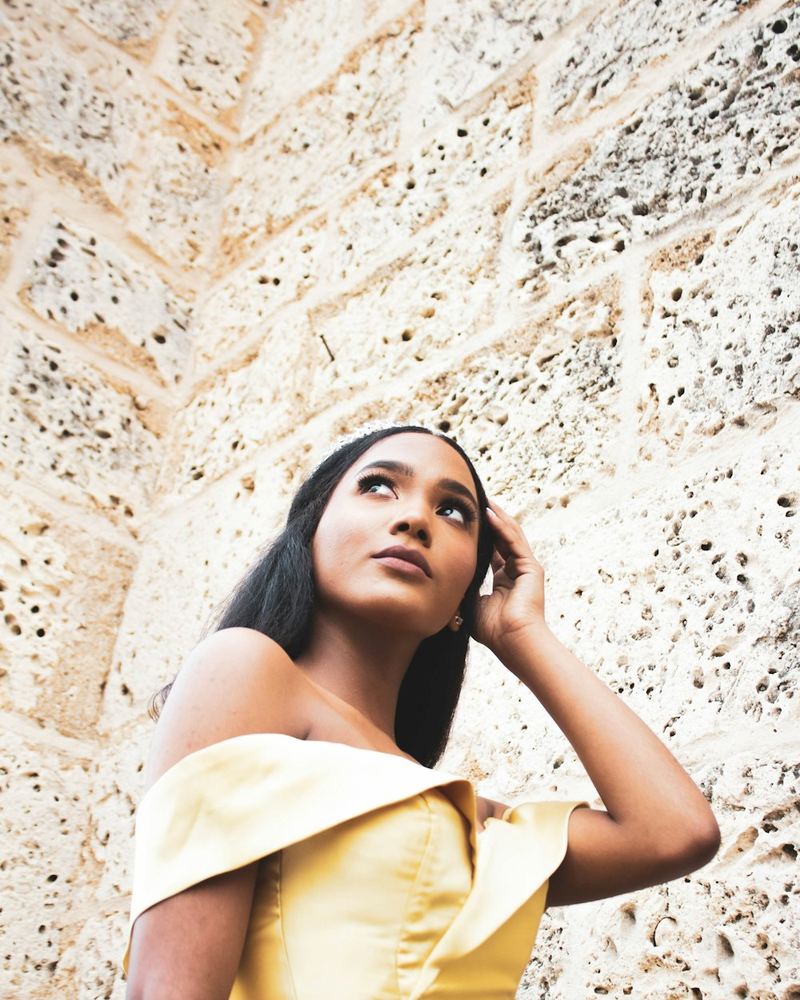 Mujer de piel morena con vestido amarillo mantequilla, foto 1 de 3